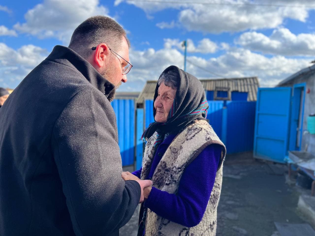 Bischof Maksym Ryabukha im Gespräch mit einer ukrainischen Frau ©ACN