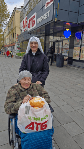 Eine Ordensschwester begleitet eine Frau zum Einkauf. (Foto: ACN)