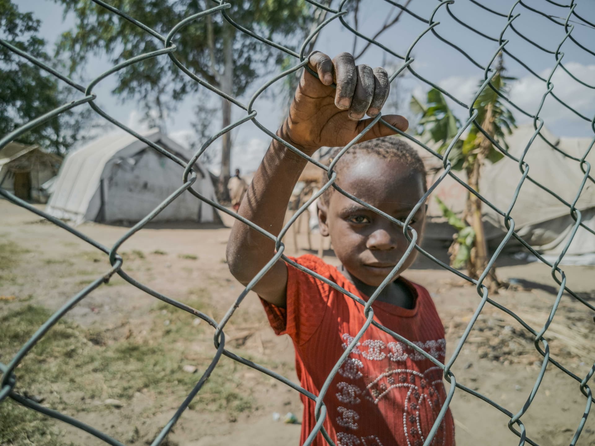 Ein Kind in einem Flüchtlingslanger hinter einem Zaun in Mosambik. (Foto: ACN) Ein Kind in einem Flüchtlingslanger hinter einem Zaun in Mosambik. (Foto: ACN)