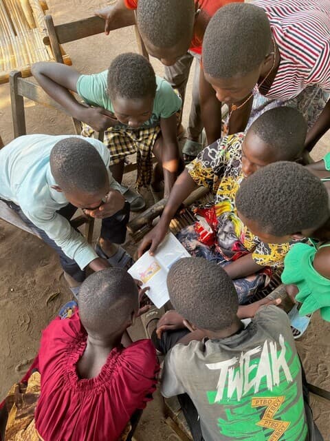 sudanesische Kinder lesen die Kinderbibel in eigener Sprache (© ACN) sudanesische Kinder lesen die Kinderbibel in eigener Sprache (© ACN)