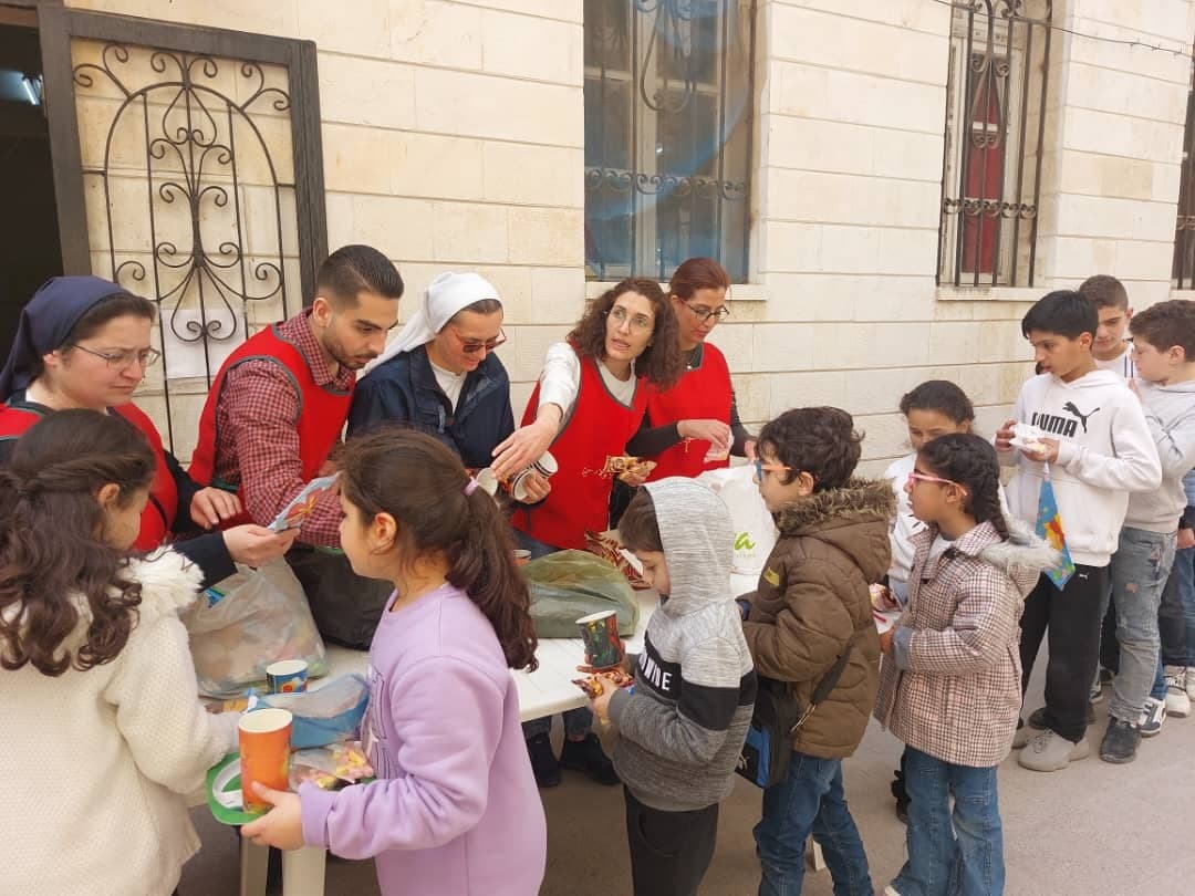 Schwestern in Syrien verteilen Lebensmittel an Kinder. ©ACN