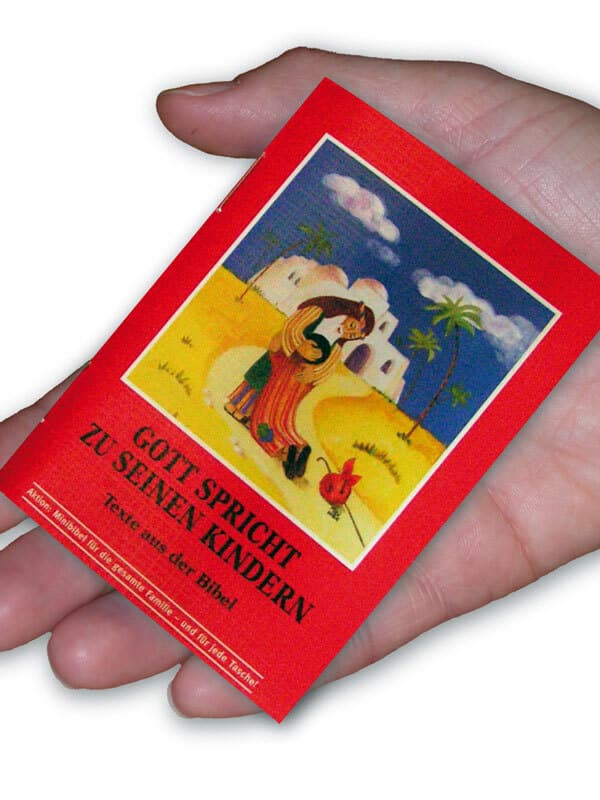 Mini kinderbibel auf handflaeche Mini kinderbibel auf handflaeche